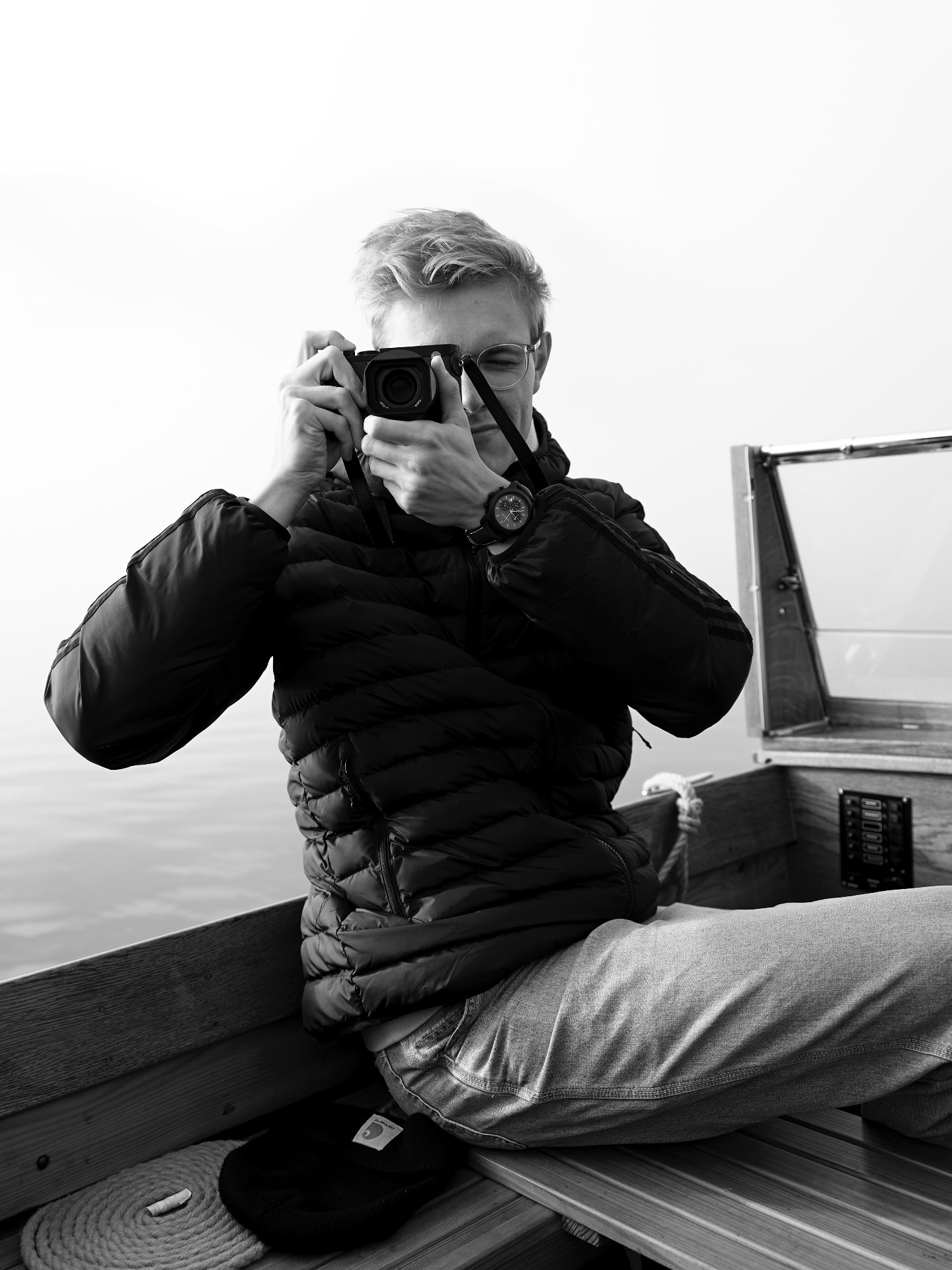 Martin Strasser shooting from a wooden boat on a foggy lake
